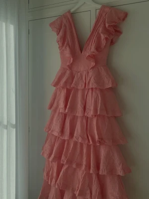 Rosa volangklänning med v-ringning - Rosa drömmig klänning från Anne Louise Boutique! Oanvänd och endast testad en gång. Nypris: 2350  