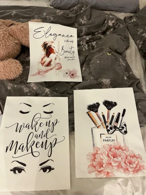 Posters med smink och citat - Tre posters med sminktema och inspirerande citat. En med parfymflaska och sminkborstar, en med texten 'wake up and makeup' och ögonillustration, samt en med kvinna och texten 'Elegance is the only beauty'. Färger i svart, rosa och vitt.