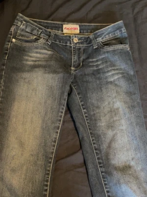 Mörkblå jeans från Faceoff - Snygga mörkblå jeans från Faceoff med slitningar och tvättade detaljer framtill. Klassisk femficksmodell absolu med knapp och dragkedja. Jeansen har en rak pass Materialet är soppt bomull med lite stretch NB.