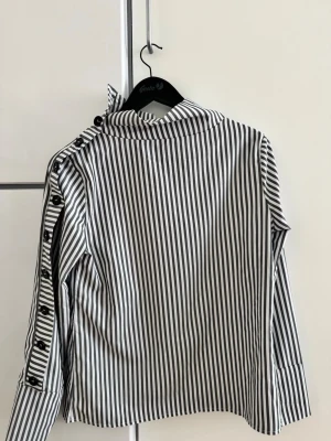 Randig blus - Blus med knappar på ärmen! OBS bara dom 2 högsta knapparna knäpps upp🥰