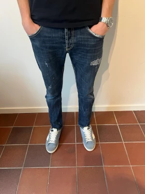 Dondup jeans - Säljer ett par riktigt feta mörkblå jeans från Dondup i slim med snygga slitningar.                 Hör av er vid intresse eller frågor. Dondups storlekar är lite skumma men W33. Modellen är 180 cm och väger 65 kg