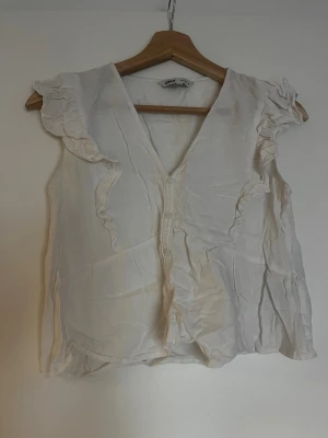 Vit volangblus från Only - Söt vit blus från Only med volangdetaljer, perfekt till sommaren!!