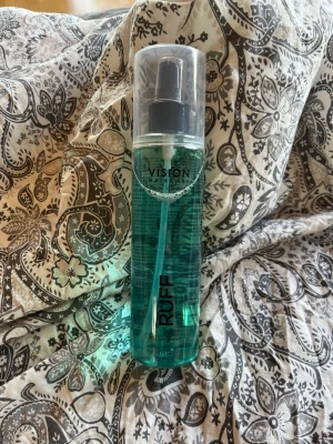Vision Haircare RUFF spray 250 ml - Fräsch blågrön spray från Vision Haircare i genomskinlig plastflaska med svart spraymunstycke och genomskinligt lock. Flaskan rymmer 250 ml och är enkel att använda för styling eller vård av håret.Använd en gång