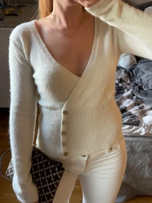 Vit stickat topp Gina tricot - storlek XS - Säljer en vit stickad topp från Gina Tricot i storlek XS. Den är sydd som omlott med söta små knappar. En väldigt söt och elegant stickad topp som passar till det mesta. Den är använda kanske tre gånger så i mycket fint skick. Hör gärna av dig vid frågor💗