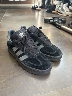 Adidas Samba OG XLG - Svarta Adidas Samba OG XLG ny pris 1400kr. Ovandel i mocka och textil, svart sula och Adidas-logga på plösen. Snygg retrostil som passar till många outfits.
