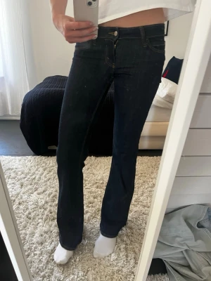 Mörkblå bootcut jeans med låg midja - Säljer ett par mörkblå bootcut jeans med låg midja från weekday. Dom är knappt använda och köptes för 500 och är i storlek 26/32