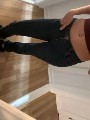 Mörkblå skinny jeans  - Snygga mörkblå skinny jeans med klassisk femficksdesign och låg midja. Jeansen har en smal passform och är tillverkade i stretchigt denim för extra komfort. Perfekta att matcha med crop tops eller hoodies.
