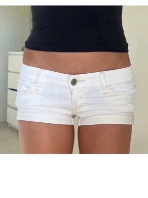 Vita denimshorts från Abercrombie - Snygga vita denimshorts från Abercrombie & Fitch med låg midja och klassisk femficksdesign. Shortsen har knapp- och dragkedjestängning samt bälteshällor. Perfekta för varma dagar och enkel att matcha med allt. Skriv för frågor !💕