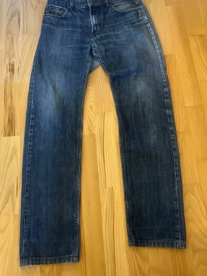 Blå raka jeans från Cerutti - Snygga blå jeans från Cerutti i storlek 31/31med raka ben och klassisk femficksmodell. Jeansen har en lätt tvättad look med slitningar vid fickorna och gylfen. Perfekta för en avslappnad stil och tillverkade i bomull.