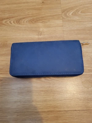 Blue faux leather wallet - New without tags, but due to not being in its packaging it has received some cosmetic defects. 5 pouches, 1 zipper pocket, 8 card slots.   Bundle discounts: two items 5% off (automatic) three items 10% off, five items 20% off. Message me before purchasing 3+ items for discount.