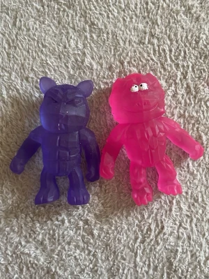 2 stretchiga stressbollar - En rosa och en lila stressboll i starka djur former. Dem är stretchiga och mjuka. 