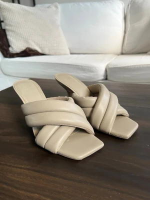 Beige sandaler med breda remmar från H&M - Jättefina Klackar/Mules från H&M i storlek 37. Köpta via Sellpy men har själv aldrig använt dem, så de är i mycket fint skick. Säljer dem vidare då de tyvärr inte kommer till användning.  Klackhöjd: ca 8 cm