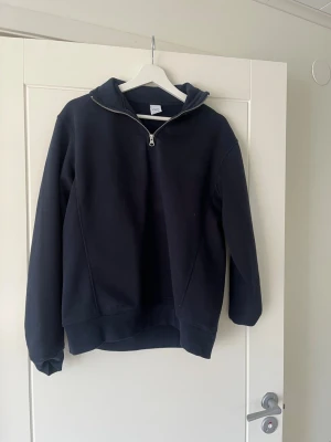 Halt quarter zipp från Zara - Snygg svart hoodie från Zara med halv dragkedja framtill och huva. Tillverkad i mjukt sweatshirtmaterial som är borstat på insidan för extra komfort. Perfekt för en avslappnad och trendig look. Klassisk passform och ribbade muddar vid ärmslut och nederkant.priset kan diskuteras