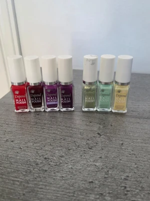 Depend nagellack i olika färger - Säljer ett set med sju Depend nagellack i små glasflaskor med vita korkar. Färgerna är röd, mörklila, lila, ljusgrön, mintgrön och ljusgul. Perfekt för dig som vill variera din nagelstil och testa olika nyanser. Den röda är det inte mycket kvar i, de andra är använda någon gång men nästan fulla. 