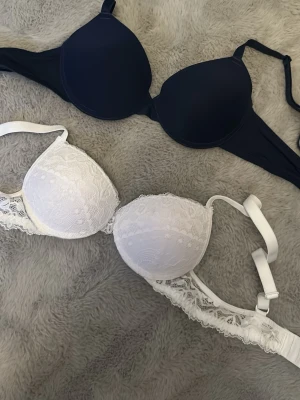 2-pack bh spets vit & svart - Jag säljer 2 bh:ar då de inte passar mig, helt oanvända☺️Köpta från Shein och ena är en vit spets bh och den andra en marinblå, ena är i Stl 70A och den andra 70B. Säljer för 40kr för båda💕