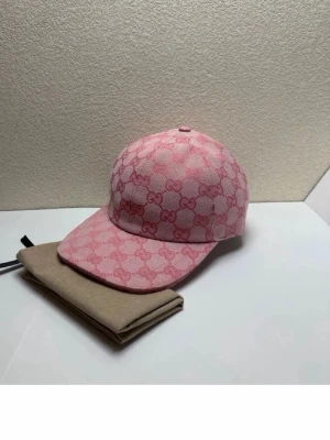 Rosa GGkeps med GG-mönster - Säljer en rosa keps med det klassiska GG-monogrammet i en rutmönstrad design. Kepsen har böjd skärm, justerbart band bak i rosa läder och är tillverkad i canvasmaterial. Perfekt för dig som vill sticka ut med en lyxig accessoar.