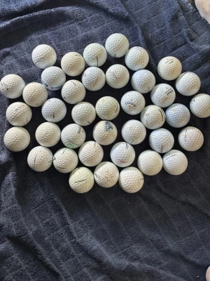 Samling golfbollar i vitt 39st - Säljer en samling med flera vita golfbollar från olika märken. Bollarna har klassisk rund form och dimpled yta, vissa med logotyper och tryck. Perfekt för dig som vill fylla på golfutrustningen eller träna på driving range.