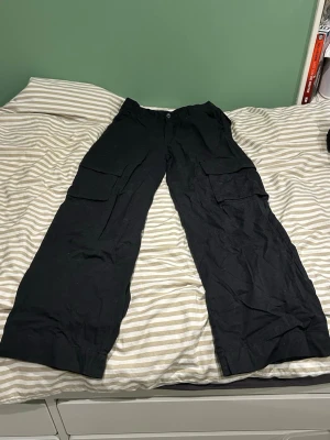 Svarta cargobyxor  - Säljer ett par svarta cargobyxor från Monki i storlek 36💕Aldrig använda