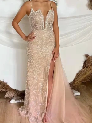 Champagnefärgad/babyrosa långklänning med slits - Elegant långklänning i champagnefärg/babyrosa med glittriga paljettdetaljer och djup v-ringning. Klänningen har tunna axelband, en hög slits på sidan. Perfekt för bal eller festliga tillfällen. Materialet känns lyxigt och skimrande. klänningen är som ny, bara använd i några timmar. Priset kan diskuteras 