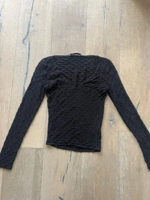 Svart omlottopp från Zara - Säljer en svart spets-isch topp från Zara. Perfekt nu till våren/sommaren med jeans eller kjol!☀️