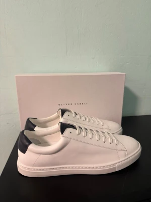 Oliver Cabell low 1 Ocean sneaker - Säljer dessa galet snygga Oliver Cabell skor. Skorna är vita med diskreta marinblåa detaljer. Skorna är helt nya, endast provade en gång inomhus. Nypris på dessa är 2000 kr.  Har du några frågor? Tveka inte att höra av dig. Allt gott från Deluxe garderoben ⭐️