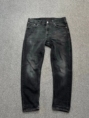 Svarta raka jeans från Nudie Jeans - ❗️ALLA FÖLJARE FÅR RABATT❗️  Nudie jeans i makalöst skick, de har storlek W31/L30 och är i modellen | Steady Eddie II (Regular tapered fit) Tvätten heter Black Change Jeansen har precis blivit lagad av Nudie repair store i Göteborg. Som du ser på låret och i grenen.  Alla mått är mätta platt:  Midja = 43.5cm Längd = 102cm Benöppningen = 17cm  Vid frågor tveka inte på att höra av dig 🙏