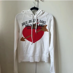 Helmut Lang hoodie - Vit hoodie ifrån Helmut lang med snyggt tryck. Storlek s. Säljer då den inte kommer till användning. Säger unisex men passar bättre för kvinnor. Hör av er vid intresse och frågor!