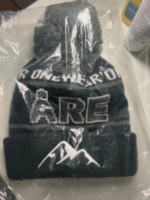 Mörkblå Åre mössa med tofs - Mössa från Onewear, Åre-text samt bergmotiv framtill. Stickad modell som passar perfekt för kalla dagar och ger en cool look.