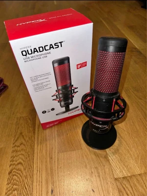 HyperX QuadCast USB Mikrofon - HyperX QuadCast är en svart och röd USB-mikrofon med ett coolt mesh-mönster och robust stativ. Perfekt för streaming, gaming och podcasting. Mikrofonen har en modern design med shock mount och touch-mute funktion. Original pris 1099kr