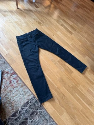 Svarta Carhartt Vicious - Snygga svarta chinos från Carhartt med klassisk rak passform och diskret logotyp på fickan. Byxorna har flera fickor och är tillverkade i ett slitstarkt bomullsmaterial som känns bekvämt och stilrent. Perfekt för dig som gillar en clean och enkel look.