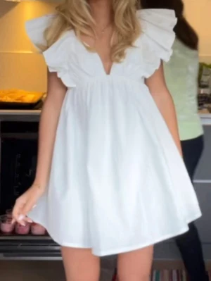 Hello Molly klänning  - Säljer den jättepopulära vita kortklänningen från hello Molly  med volangärmar och v-ringad hals. Perfekt till studenten. Helt ny med lapp kvar 