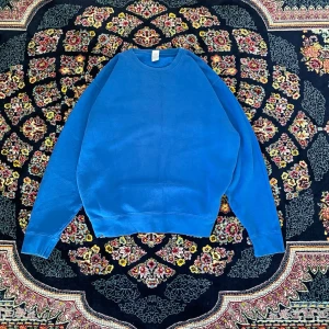 Blå boxyfit stickad sweatshirt - En enkel och stilren blå stickad sweatshirt med rund hals och långa ärmar. Tröjan har en avslappnad passform och ribbade muddar vid ärmslut och nederkant. Perfekt för en chill och casual look.