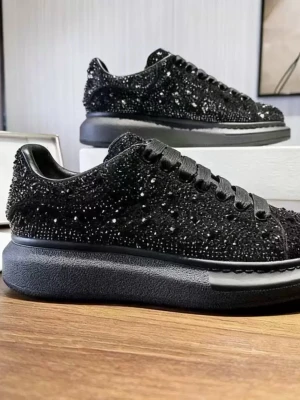 Svarta sneakers med strassdetaljer - Snygga svarta sneakers med glittrande strass över hela ovandelen och tjock sula. Skorna har klassisk låg profil, svarta skosnören och en modern chunky design som sticker ut. Perfekta för dig som vill ha något extra till din outfit.