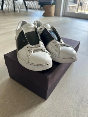 Valentino Open - Ett par vita sneakers från Velentino Garavani. Grön detalj över snörningen. Originalbox och dustbag ingår. Hör av er vid frågor!