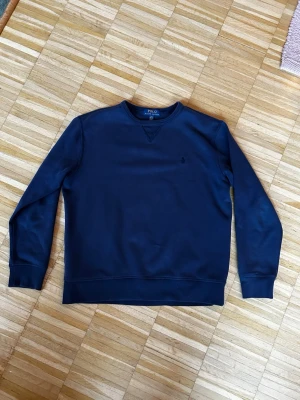 Ralph Lauren sweatshirt - Mörkblå sweatshirt från Polo Ralph Lauren med klassisk rund halsringning och diskret logobrodyr på bröstet. Tröjan har långa ärmar, ribbade muddar och är gjord i mjukt material som känns skönt mot huden. 