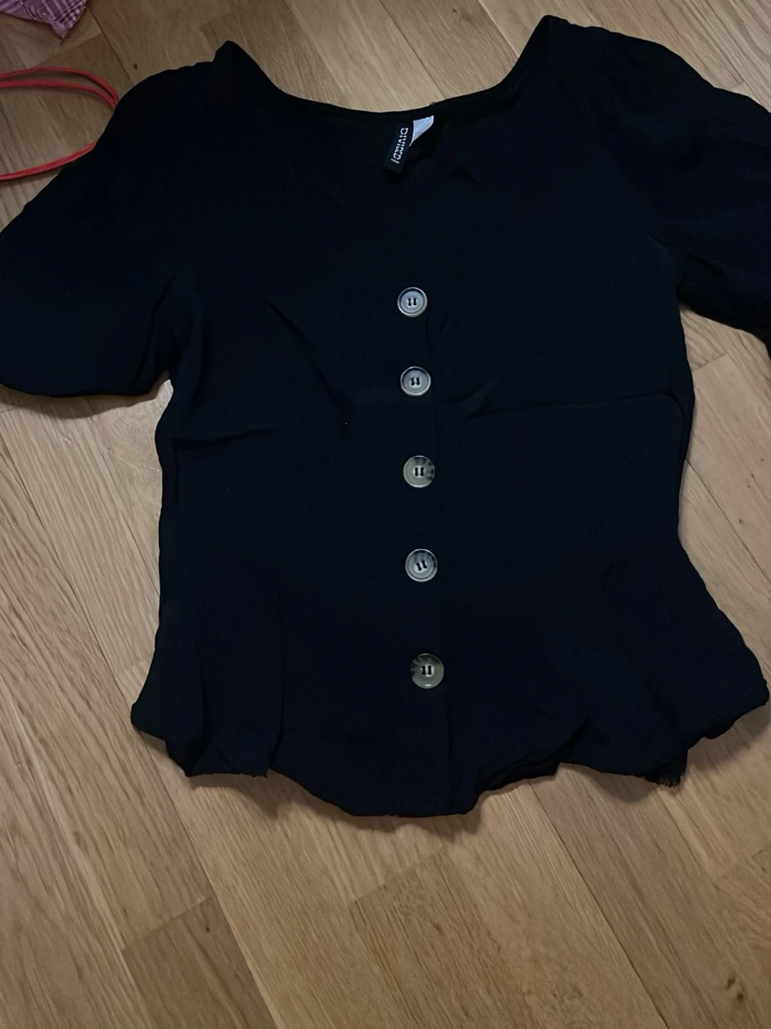 svart blus med stora knappar