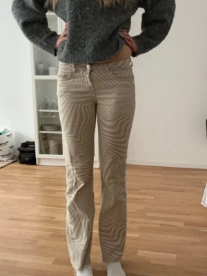 Beige randiga jeans från H&M - Jättefina och bekväma beige randiga jeans från H&M Divided. Är lite slitna längst ner på benen, säljs pga att de inte används. Sitter bra i midjan och är även långa på mig som är 178 cm.
