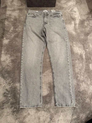 Grå raka jeans från Jack & Jones - Gråa raka jeans från Jack & Jones (Chris). Byxan är loosefit och storlek 31/34.