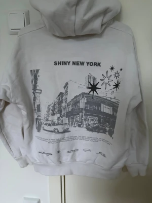 Vit hoodie med New York-tryck - Vit hoodie från pull and bear. Knappt använd, storlek xs. 