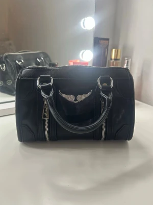 Handväska - Jag säljer en väska som efterliknar Zadig Voltaire väskorna, den är köpt i USA. De är ett stort fack och två små fack på vardera sida. Har använd bara 1 gång.  Ordinarie pris är 500kr💕