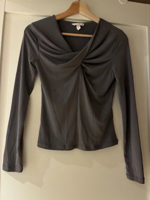 V-ringad topp - En figurnära, långärmad topp i mjuk, stretchig trikå. Köpt förra sommaren men aldrig använd, endast tvättad. Orig. pris 249kr Säljer också samme topp men i vinrött färg. Se annan annons.   Från rökfritt hem men vi har hundar.