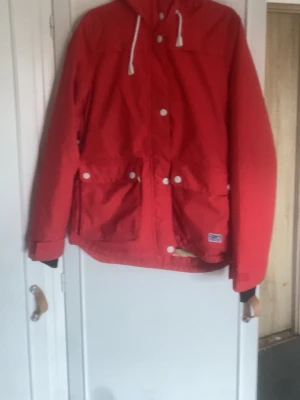 Röd vindjacka med huva - Röd jacka passar till vad som helst om man tycker om sånna typer av jackor, använd en gång storlek S-M 