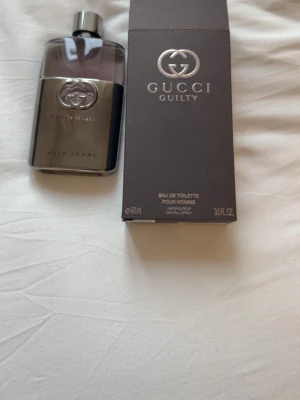 Gucci Guilty Pour Homme EdT 90ml - Gucci Guilty Pour Homme Eau de Toilette är en maskulin parfym i en elegant, mörkgrå och silverfärgad glasflaska med metallisk finish. Flaskan har Guccis ikoniska logga och rymmer 90 ml. Doften är modern och stilren, perfekt för dig som gillar exklusiva märkesparfymer.
