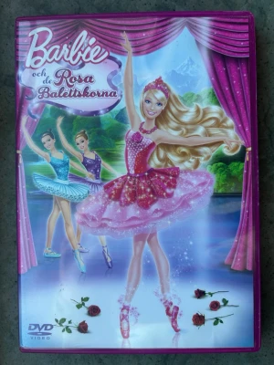 Barbie och de rosa balettskorna dvd - Barbie och de Rosa Balettskorna är en animerad film från 2013. Speltid: 1 timme, 16 minuter. Bildformat: 1.78:1 Anamorfisk widescreen. Region 2. Bonusmaterial inkluderar: Bortklippta tabbar, Musikvideo "Life in the Dreamhouse", Barbie-avsnitt "Life in the Dreamhouse".  Finns på språk: Svenska, Engelska, Finska  OBS!! skivorna är begagnade så det kan förekomma repor/hairlines på skivorna, men då jag kollar igenom alla filmer jag säljer garanterar jag att alla funkar felfritt om inget annat står! 