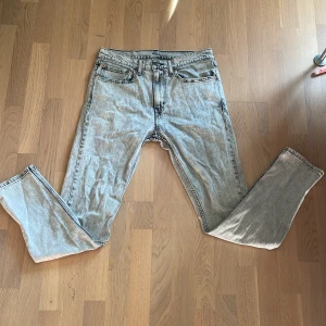 Levi's 515 ljusgrå jeans W32 L32 - Säljer ett par Levi's 515 jeans i ljusgrå tvätt med klassisk femficksdesign och raka ben. Jeansen har en snygg vintagekänsla och är tillverkade i slitstarkt bomullsjeans. Perfekta för dig som gillar en avslappnad och tidlös stil.