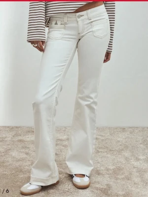 Vita bootcut low waist jeans ifrån nelly  - Snygga vita bootcut jeans från Wrangler med klassiska fem fickor och ljusa kontrastsömmar. Jeansen har hög midja och utsvängda ben, vilket ger en retroinspirerad look. Tillverkade i mjuk denim med stretch för extra komfort.