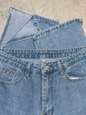 Jeans med öppning - Högmidjade jeans med en designad öppning vid ankeln på vardera ben. Storlek S/M med en aning tunnare och stretchigare material. Inga defekter eller tecken på användning, säljer då jag föredrar lågmidjade jeans. Kan självklart diskutera pris, hör av dig vid frågor!🩵