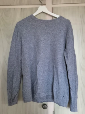 Ljusgrå/blå stickad tröja - En enkel och stilren ljusgrå stickad tröja med rund hals och långa ärmar. Tröjan har en mjuk och tunn stickning som passar perfekt till lager på lager. Inga synliga loggor eller mönster, bara klassisk och clean design.         Alla kläder rollas innan dom skickas hem då det finns katt i hemmet🐈 Jag stryker och tvättar INTE innan jag skickar det får du stå för själv så det blir som du vill ha det🤗