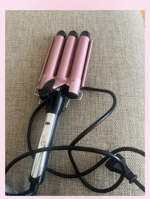 Rosa vågtång för hår - 💓Säljer en rosa vågtång med tre cylindrar för att skapa snygga vågor i håret. Handtaget är svart och silverfärgat med två knappar och sladd med EU-kontakt. Perfekt för dig som vill fixa beach waves snabbt och enkelt.💗