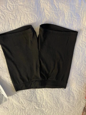 Svarta ribbade cykelshorts - Säljer ett par svarta ribbade cykelshorts med midwaist passform. De är stretchiga och perfekta till sommaren. Passar dig som gillar en enkel och clean stil.